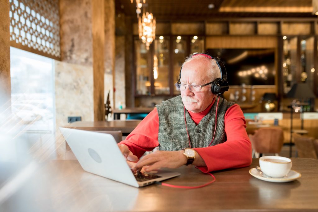 Hipster elderly man working in cafe