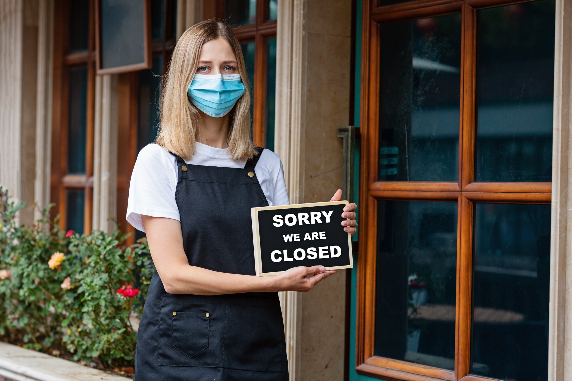 Restaurant owner standing near note closed. Shutdown coronavirus covid-19 quarantine